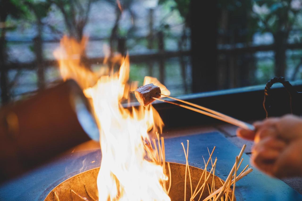 Hotel Arima Onsen Tocen Goshobo Kobe Zewnętrze zdjęcie A piece of meat being cooked over a fire